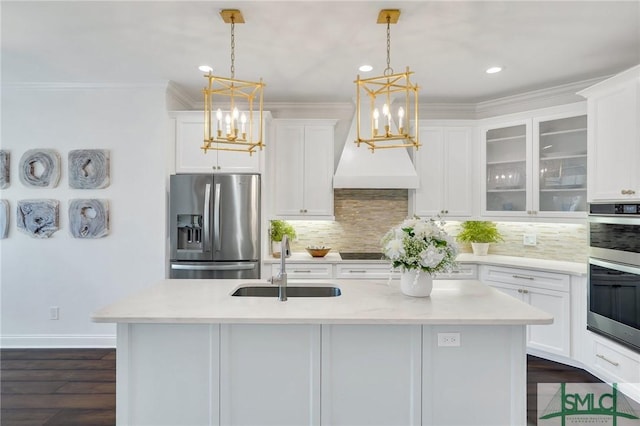 kitchen with stainless steel appliances, light countertops, white cabinets, a sink, and a chandelier