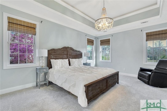 carpeted bedroom featuring a tray ceiling, visible vents, an inviting chandelier, ornamental molding, and baseboards