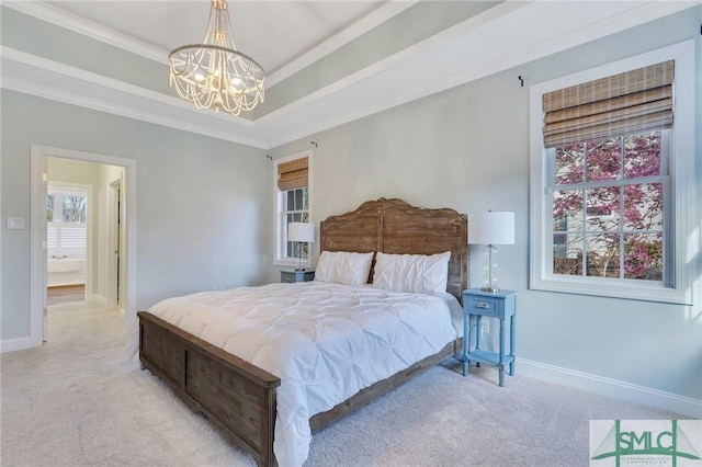 carpeted bedroom with ornamental molding, a tray ceiling, a notable chandelier, and baseboards