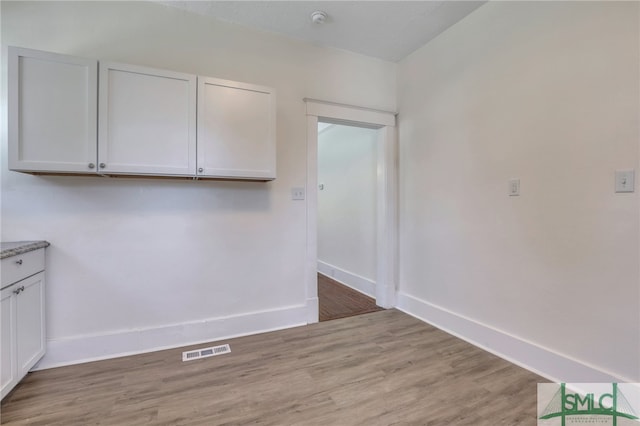 interior space featuring light hardwood / wood-style floors and white cabinets