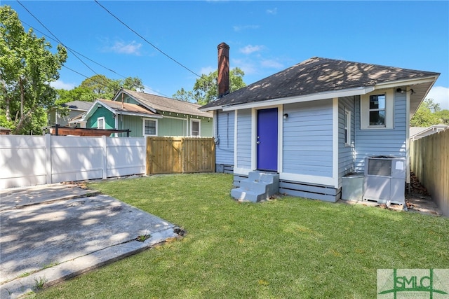 rear view of property featuring an outbuilding and a lawn