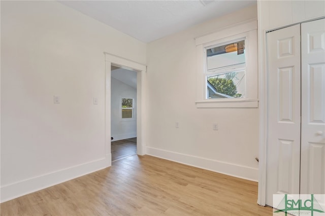 empty room featuring lofted ceiling and light wood-type flooring