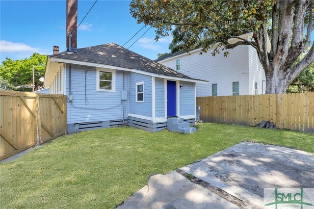 back of property with a patio area and a yard