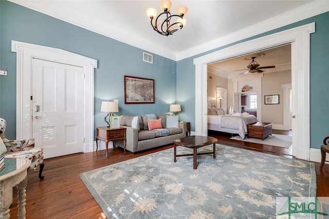 living room with ornamental molding, ceiling fan with notable chandelier, and hardwood / wood-style flooring