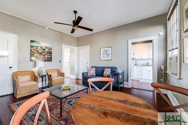 living room featuring cooling unit, ceiling fan, dark wood-type flooring, and sink