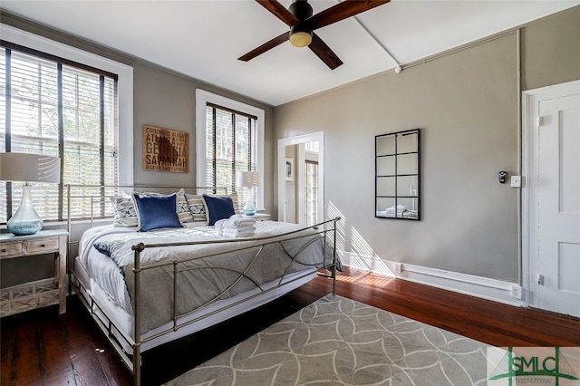 bedroom with multiple windows, ceiling fan, and dark hardwood / wood-style flooring