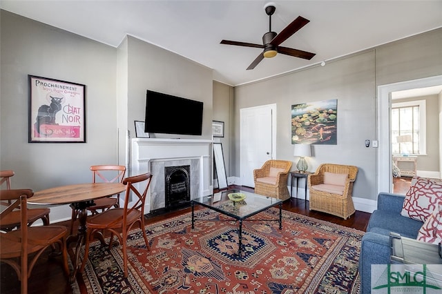 living room featuring ceiling fan and dark hardwood / wood-style flooring