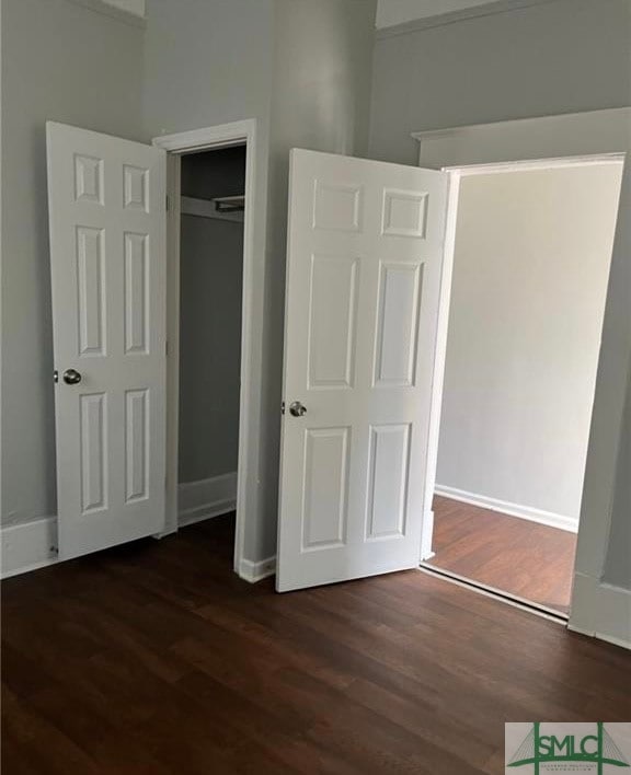 unfurnished bedroom featuring a closet and dark hardwood / wood-style floors