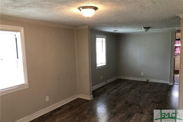 spare room featuring dark wood-type flooring, crown molding, and plenty of natural light