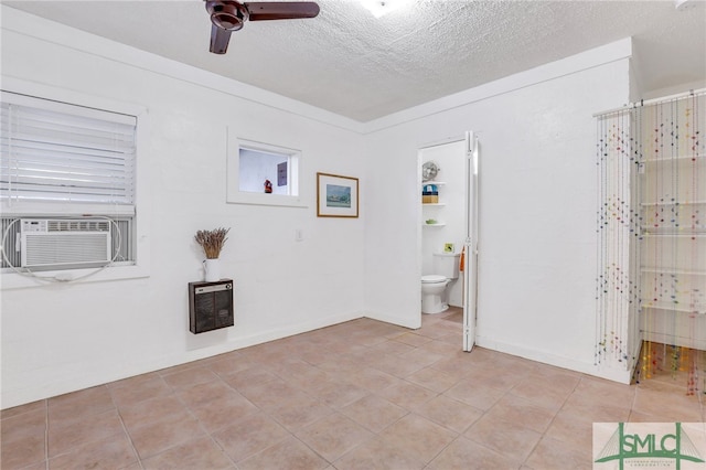 unfurnished room with cooling unit, light tile patterned flooring, heating unit, a textured ceiling, and ceiling fan