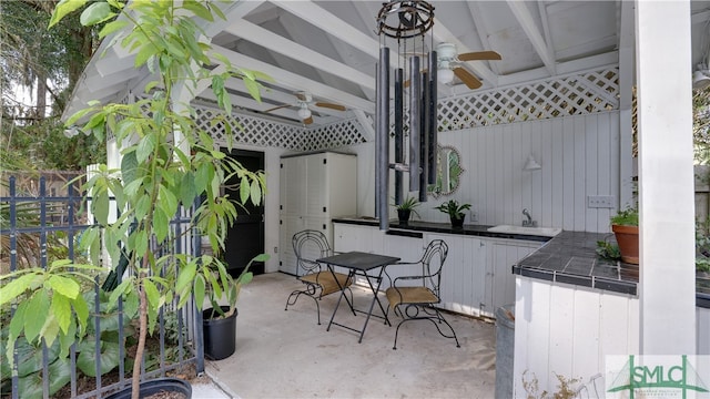 view of patio / terrace featuring a sink, a ceiling fan, and fence