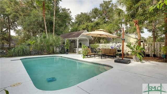 view of pool with an outdoor living space, a fenced in pool, a patio, and fence