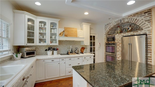 kitchen with glass insert cabinets, backsplash, appliances with stainless steel finishes, and white cabinets