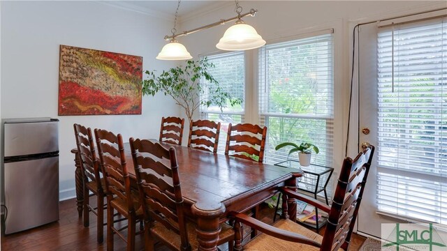 dining space featuring crown molding and hardwood / wood-style flooring