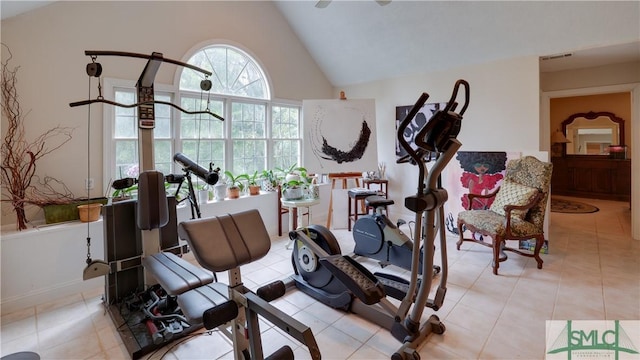 workout room with high vaulted ceiling and light tile patterned floors