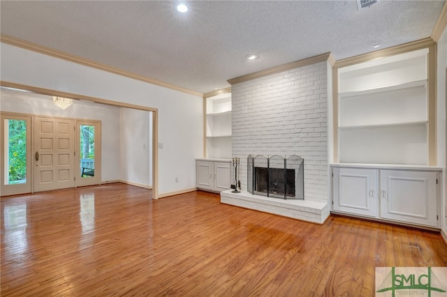 unfurnished living room featuring a textured ceiling, light hardwood / wood-style flooring, a fireplace, and ornamental molding