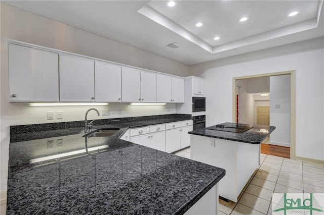 kitchen featuring white cabinetry, black appliances, a center island, and sink