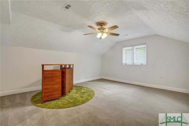 bonus room featuring ceiling fan, a textured ceiling, lofted ceiling, and carpet floors