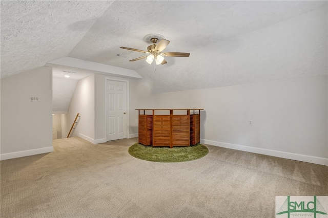 bonus room featuring ceiling fan, a textured ceiling, lofted ceiling, and light colored carpet