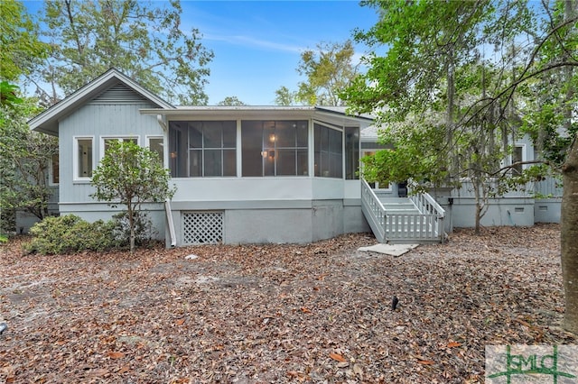 rear view of house featuring a sunroom