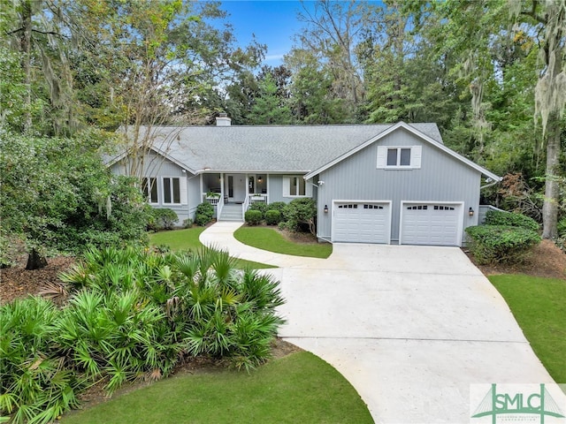 view of front facade featuring a front yard, a garage, and a porch