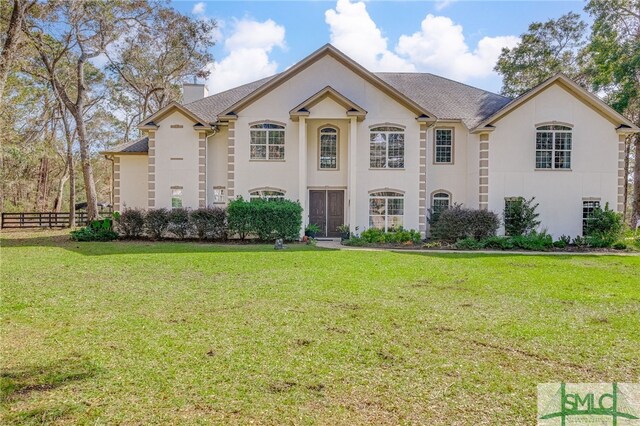 579 Turkey Trot Trl, Richmond Hill, GA 31324 - french country inspired facade with stucco siding, a chimney, and a shingled roof