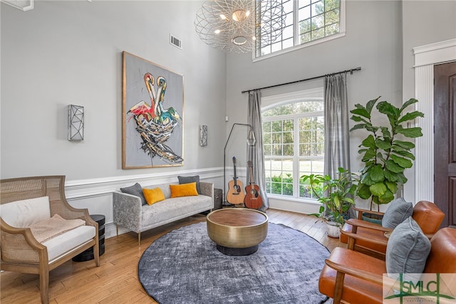 living area featuring an inviting chandelier, a high ceiling, and light wood-type flooring