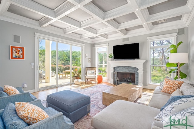 living area featuring beam ceiling, a fireplace with flush hearth, visible vents, and light wood-style floors