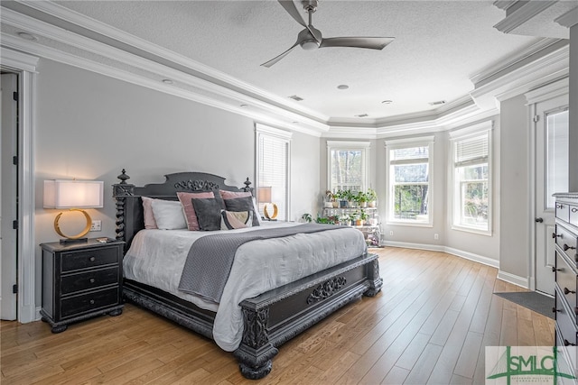 bedroom featuring hardwood / wood-style flooring, ceiling fan, ornamental molding, and a textured ceiling