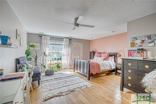 bedroom featuring ceiling fan, a textured ceiling, and light wood-style floors