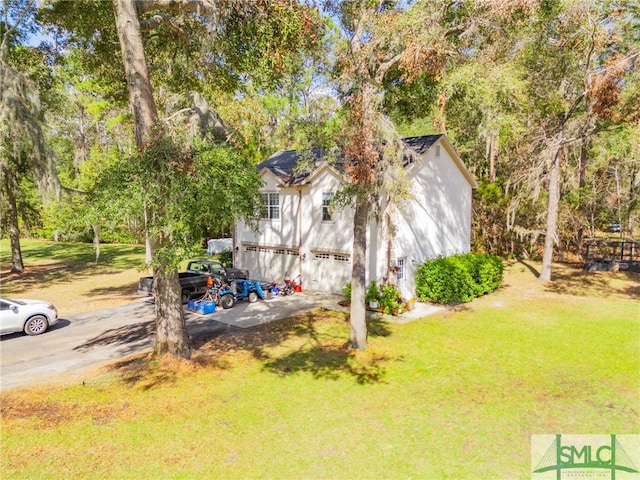 579 Turkey Trot Trl, Richmond Hill, GA 31324 - view of green lawn with a garage, driveway, and view of scattered trees