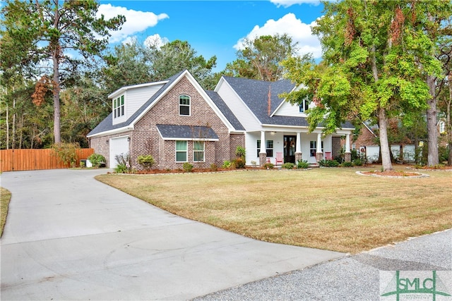 view of front of house featuring a front yard, a garage, and a porch