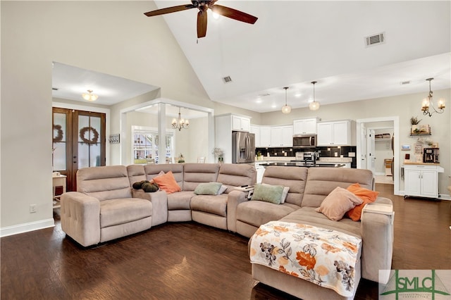 living room featuring dark hardwood / wood-style floors, high vaulted ceiling, and ceiling fan with notable chandelier