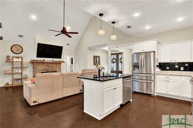 kitchen with high vaulted ceiling, white cabinetry, stainless steel appliances, and sink