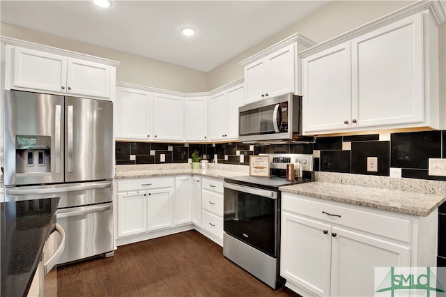 kitchen with white cabinets, stainless steel appliances, and dark hardwood / wood-style floors