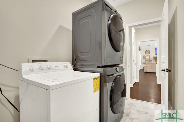 clothes washing area featuring stacked washer / drying machine and light wood-type flooring