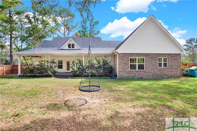 rear view of property featuring a lawn