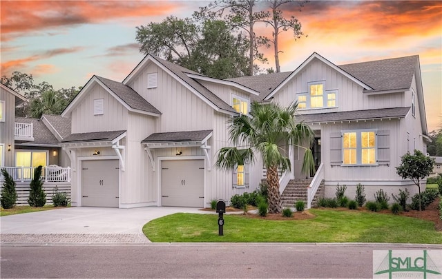 modern farmhouse featuring a garage and a lawn