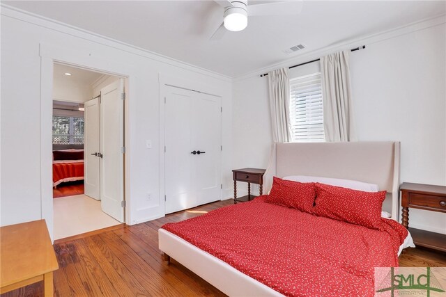 bedroom with ornamental molding, hardwood / wood-style floors, and ceiling fan