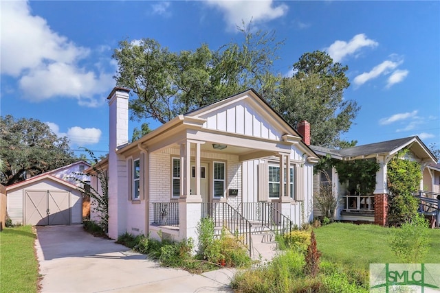 bungalow-style house featuring covered porch, a storage shed, and a front yard