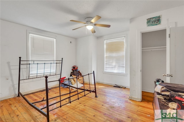 bedroom featuring a closet, light hardwood / wood-style floors, and ceiling fan