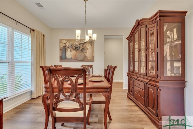 dining room featuring light hardwood / wood-style flooring and an inviting chandelier