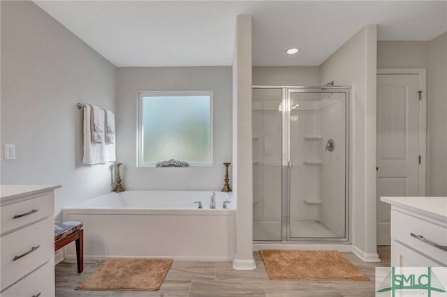 bathroom with vanity and independent shower and bath