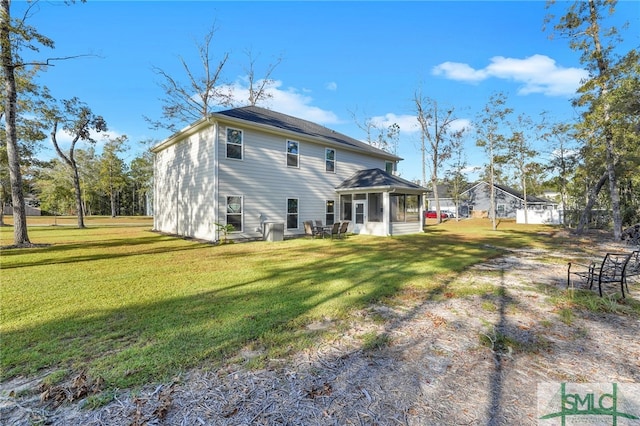 rear view of house with a sunroom and a lawn