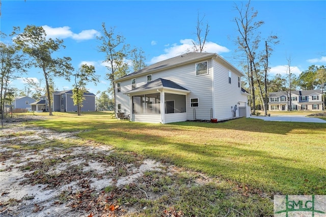 back of property with a sunroom and a yard