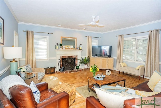 living room with hardwood / wood-style floors, a brick fireplace, and a healthy amount of sunlight