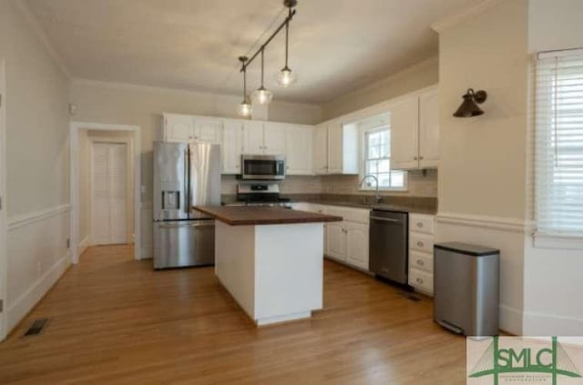 kitchen featuring a center island, white cabinetry, light wood-style floors, and stainless steel appliances