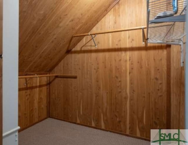 walk in closet with carpet flooring and vaulted ceiling