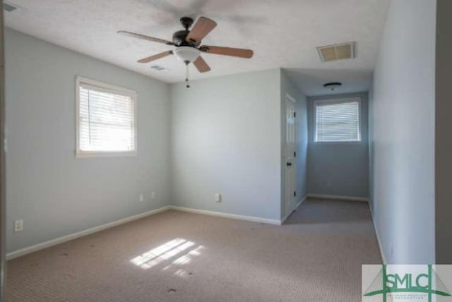 unfurnished bedroom with baseboards, a ceiling fan, carpet flooring, and visible vents