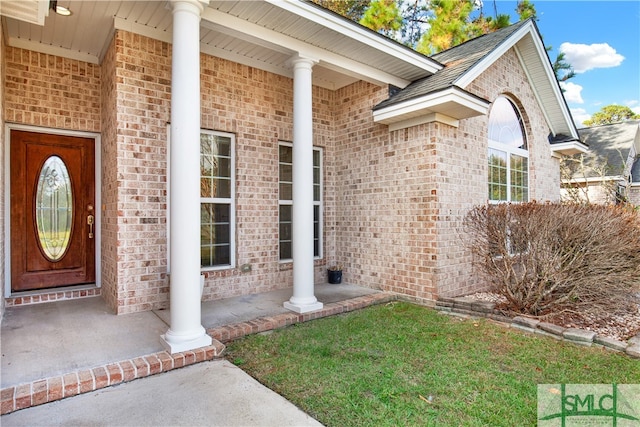 entrance to property with a lawn